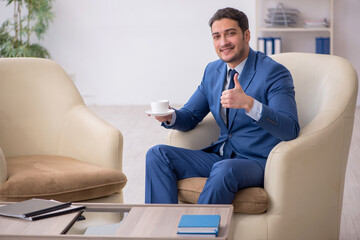 Young male employee waiting for business meeting