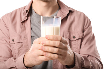 Young man with glass of milk on white background, closeup