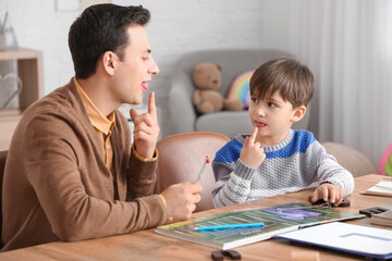 Speech therapist working with little boy in office