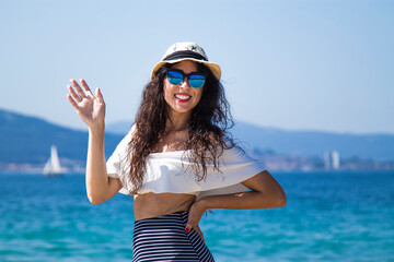 portrait of woman enjoying on the beach and waving hand