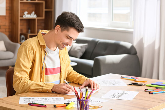 Young male calligrapher working at home