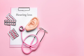 Clipboard with text HEARING LOSS, stethoscope and pills on color background