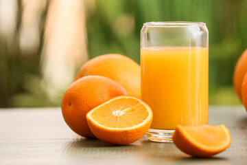 Glass of tasty orange juice on table outdoors, closeup