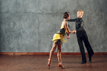 Fototapeta premium Young couple dancers dancing ballroom dance cha-cha-cha