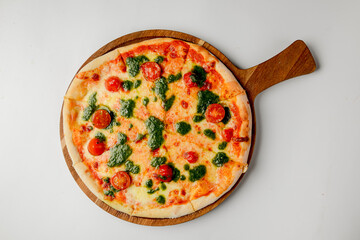Pizza Margherita made from cherry tomatoes and basil sauce, rustic fresh pizza over white background.