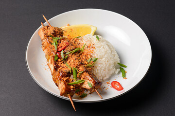 Chicken kebabs with bell peppers, onions, zucchini, and cherry tomatoes. Served with rice and a piece of lemon