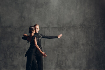 Fototapeta na wymiar Young couple in black dancing ballroom dance Paso Doble