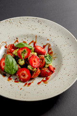 Caprese salad with strawberries. Salad with mozzarella, tomatoes, basil and strawberries.