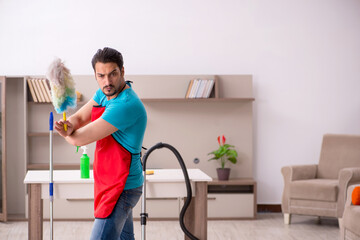 Young male contractor cleaning the house