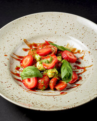 Caprese salad with strawberries. Salad with mozzarella, tomatoes, basil and strawberries.