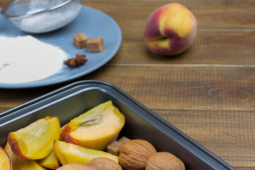 Naklejka na ściany i meble Chopped peaches and walnuts in baking sheet. Sieve and flour on plate.