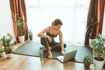 Fototapeta na wymiar woman do yoga near laptop online learning teaching