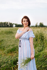 Beautiful young woman in summer in a wheat field