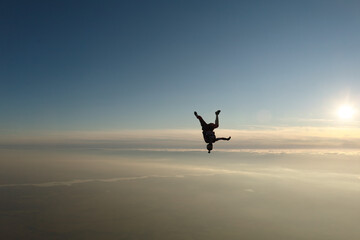 Fototapeta na wymiar Skydiving. Freefly jump. A girl is having fun in the sky.