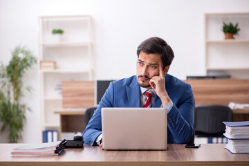 Young male employee sitting at workplace