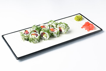 Sushi rolls with tuna, cucumber and cream-cheese in chopped dill. Served on a white plate over white background.