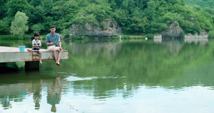 Chinese father and son fishing outdoors,4K