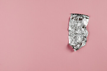 Crumpled foil opposite the pink background. Small piece of alumi