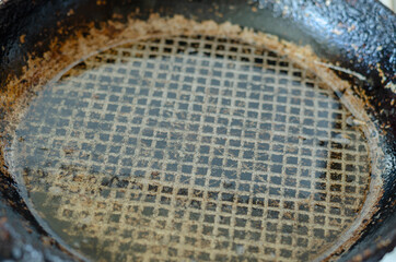 Fototapeta na wymiar An old frying pan with red-hot cooking oil. Close-up of a cast-i