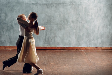 Young couple boy and girl dancing in ballroom dance Viennese Waltz.