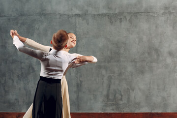 Young boy and girl dancing in ballroom dance Viennese Waltz.