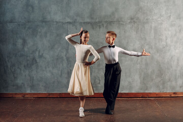Young boy and girl dancers dancing in ballroom dance Samba. - obrazy, fototapety, plakaty