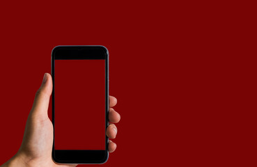 Female holding a black smartphone with a touch screen in Red background.