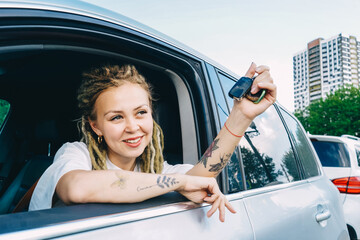 Happy smiling woman with car key. Driving