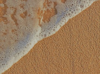 Close-up of clean ocean water washing onto beach sand, diagonal orientation