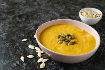 Concept of tasty food with pumpkin soup on black smokey table
