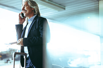 Businessman at airport waiting lounge talking on phone