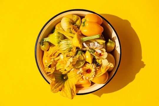 yellow vegetables and flowers in the bowl