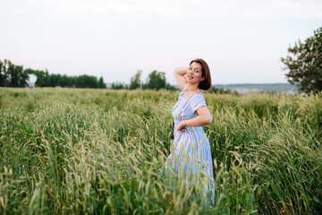 Beautiful young woman in summer in a wheat field