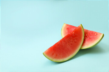 Fototapeta na wymiar Ripe watermelon slices on blue background, space for text