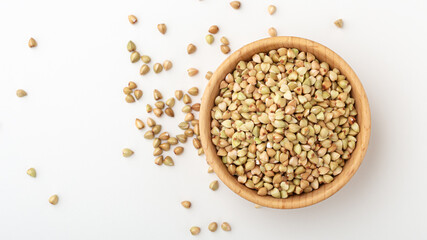 Buckwheat in wooden bowl on white background
