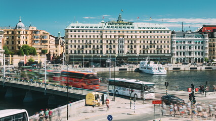 Stockholm, Sweden. Traffic With Cars And Buses. Grand Hotel Located On The Peninsula Blasieholmen....