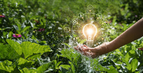 Hands of men holding and glowing light bulb in the splash water. Symbol. Against nature on green...