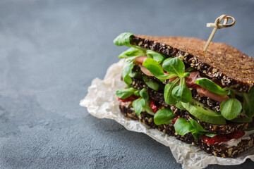 Fresh rye bread sandwich with ham, lettuce and tomato