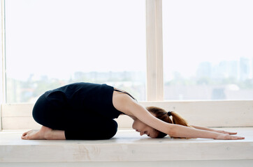 woman near the window yoga performance meditation flexibility