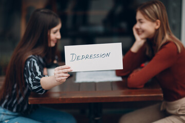 Hidden depression concept. Woman holding white sheet paper labeled word Depression in hand. Two...