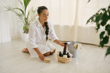 Young woman cleaning room using natural wooden brush. Sustainable eco friendly tools for cleaning.