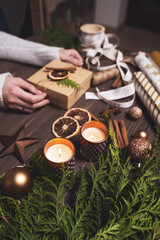 Women's hands decorate Christmas gift box with eco-friendly natural decorations. Creative diy hobby.
