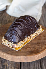 Chocolate dessert on a wooden background. Cake filled with banana and cream