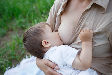 baby boy sucking milk from mothers breast. Portrait of mom and baby.