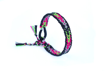 Woven friendship bracelet with bright colorful pattern handmade of thread isolated on white background