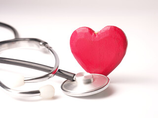 Stethoscope with a red heart shape on a white table, health care concept