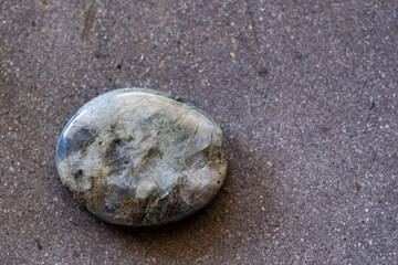 Pierre roulée polie galet de labradorite sur un fond noir - Minéral naturel