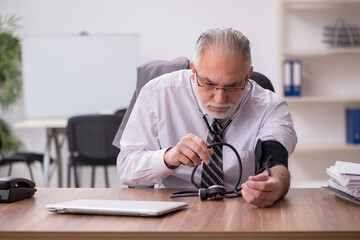 Aged male employee suffering at workplace