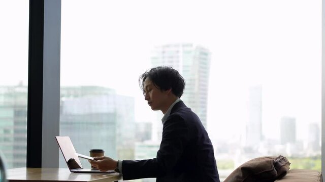 パソコンと携帯を見るビジネスマン