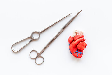 Heart surgery concept with surgical instruments and heart model made of plastiline